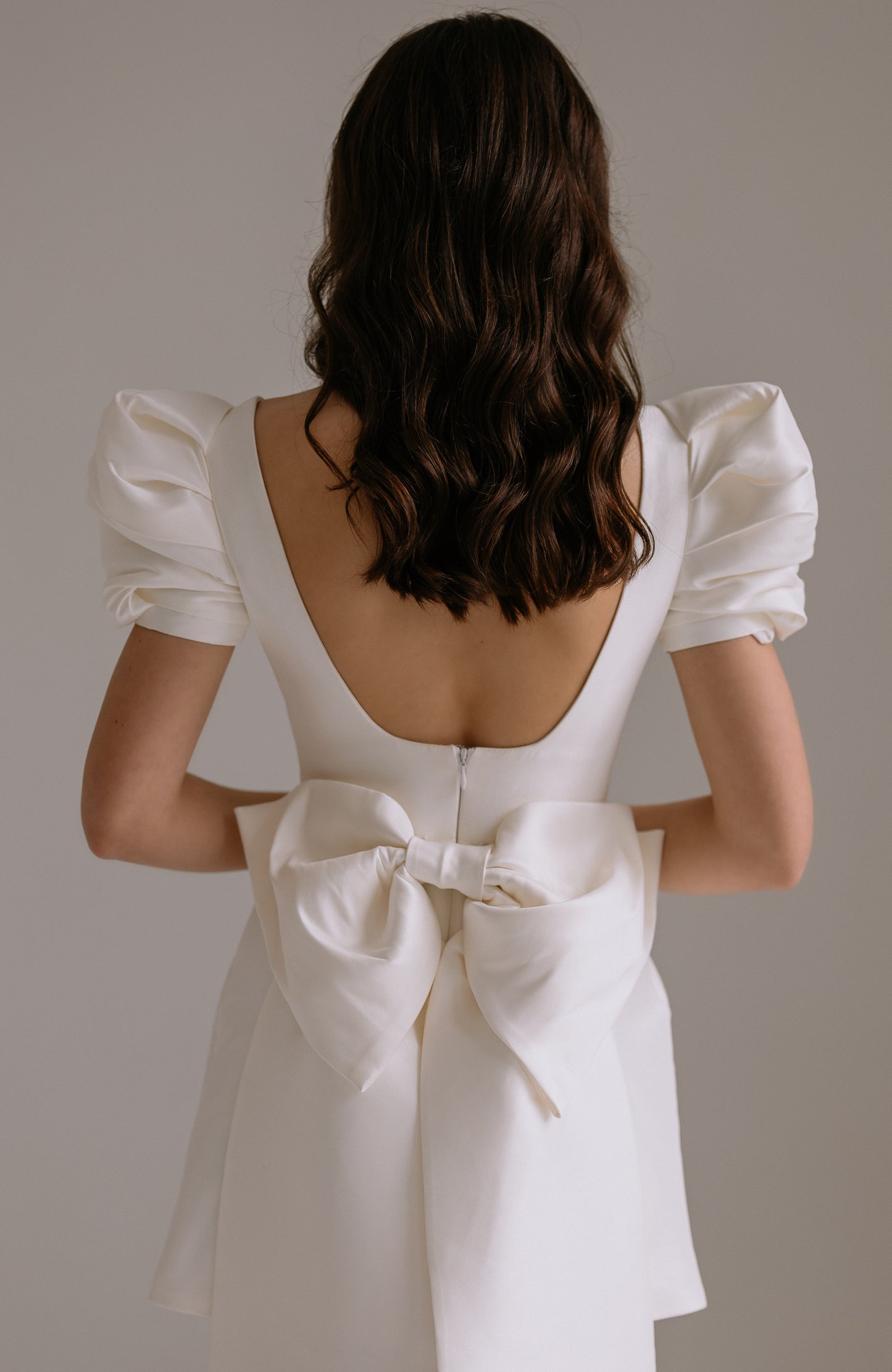 Leonie dress statement bow detail showing dramatic train and press stud attachment