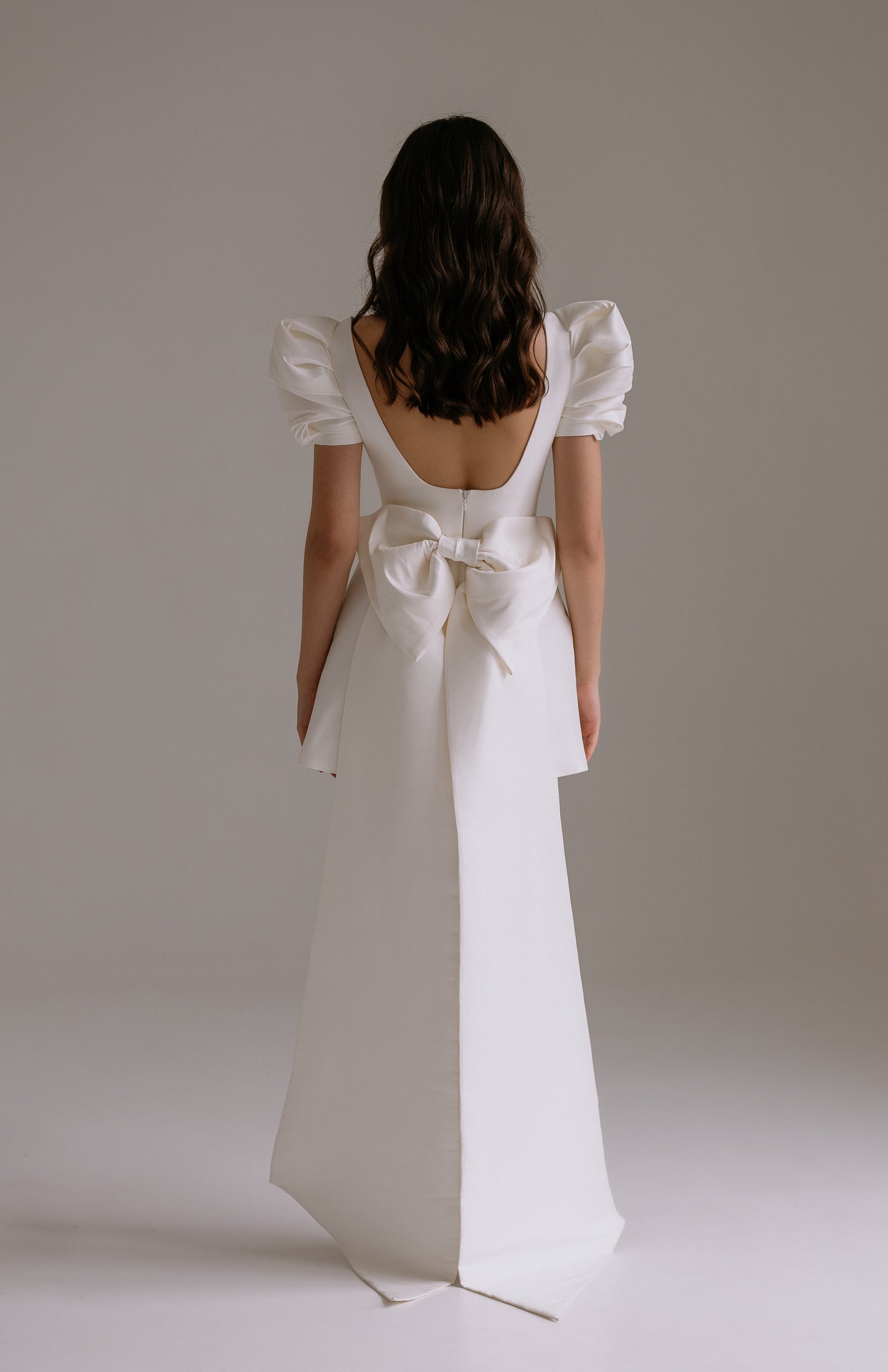 Leonie dress back view showing luxurious bow and train attachment with press studs