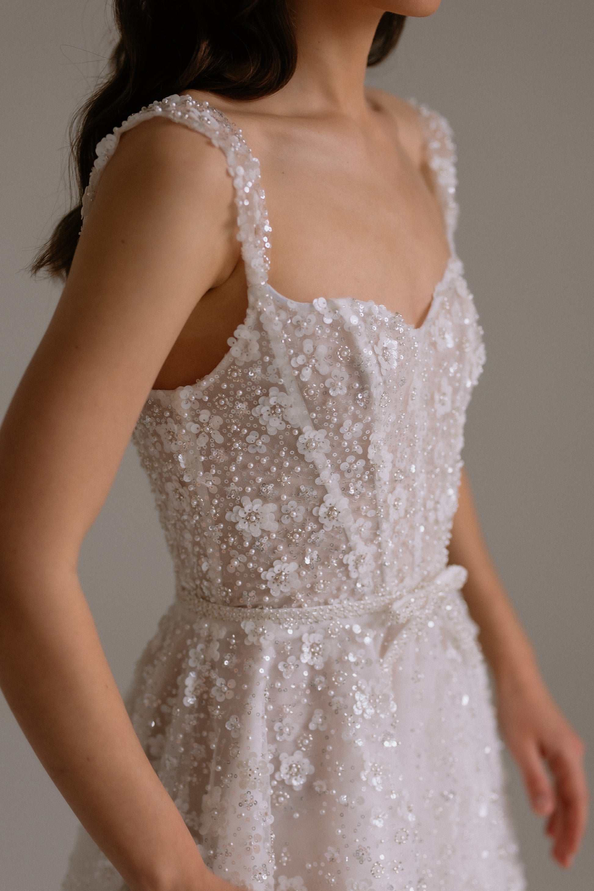Carrie short wedding dress detail view showing fabric details such as sequin flowers, beads and pearls. Perfect as engagement dress, after party wedding dress or bridal shower dress.