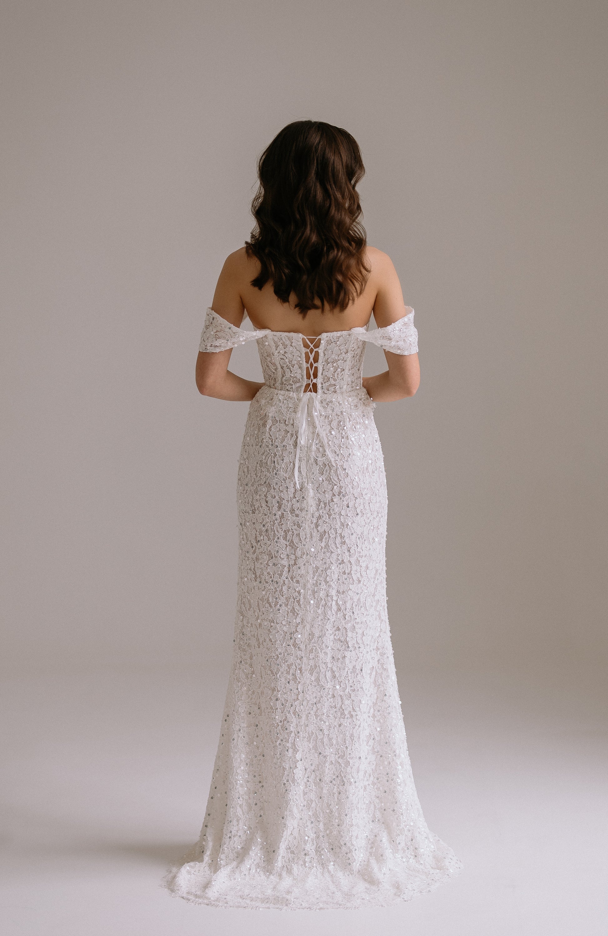 Alessia two piece set back view showing romantic lace up corset detail and flowing sequined skirt
