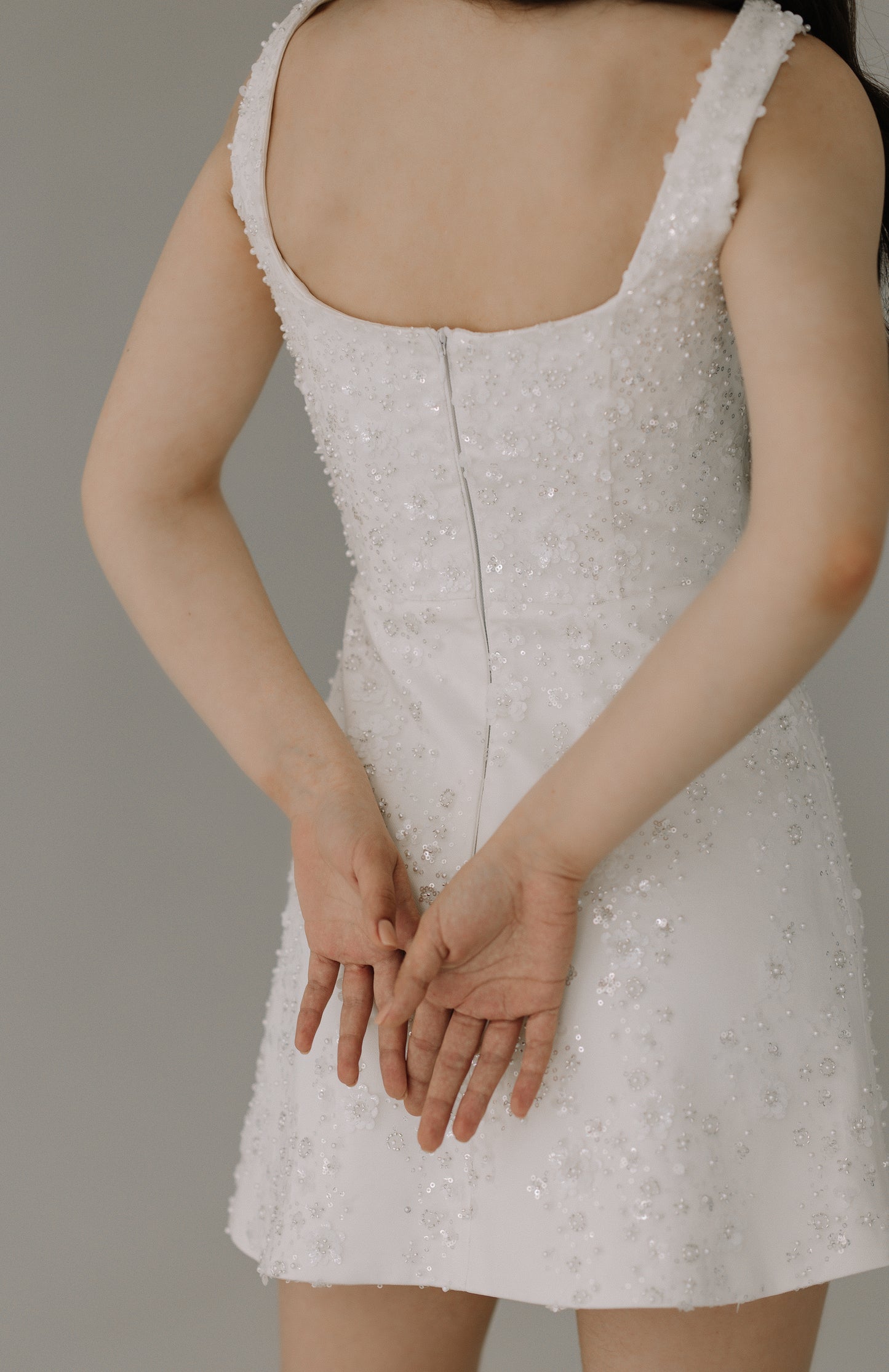 Dalia dress close back view showing luxurious heavy satin and intricate sequin flower details

